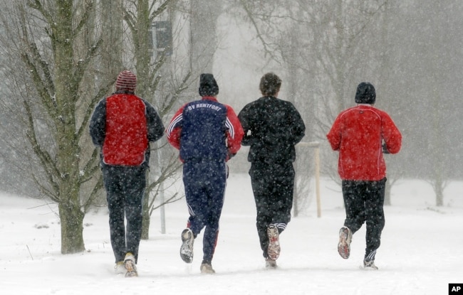 Joggers run together in the snow in Gladbeck, Germany, Sunday, Dec. 20, 2009. (AP Photo/Martin Meissner)