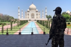 FILE - A security officer stands guard on the empty grounds of the historic Taj Mahal during a coronavirus lockdown, in Agra, India, April 2, 2020.