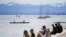 FILE - People enjoy the sun at the shore of Lake Starnberg, in Starnberg, near Munich, southern Germany, May 9, 2021, with the Alps in the background.