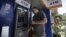 American tourist Ryan Russell withdraws cash from an ATM machine using a MasterCard card, the first such ATM transaction, Rangoon, Burma, November 15, 2012. 