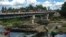 FILE - People bathe in the Massacre River, named for a bloody battle between Spanish and French colonizers in the 1700s, on the border with Haiti in Ouanaminthe, Dominican Republic, Nov. 19, 2021. 