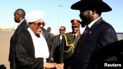 Sudanese President Omar Hassan al-Bashir shakes hands with South Sudan's President Salva Kiir, right, at Khartoum Airport, Nov. 4, 2014. 