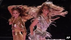 Penyanyi Shakira (kiri) dan Jennifer Lopez menggoyang panggung pertunjukan paruh waktu NFL Super Bowl ke-54, di Miami Gardens, Minggu, 2 Februari 2020.