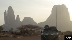 FILE - A French armored vehicle drives by Mount Hombori, in Mali's Gourma region, March 27, 2019.