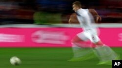 FILE - In this Oct. 11, 2019, file image taken with a slow shutter speed a soccer player runs for the ball during the Euro 2020 group A qualifying soccer match in Prague, Czech Republic.