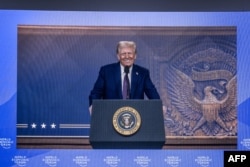 Presiden Amerika Serikat Donald Trump terlihat di layar besar saat menyampaikan pidato di pertemuan tahunan Forum Ekonomi Dunia (WEF) di Davos, 23 Januari 2025. (Fabrice COFFRINI/AFP)