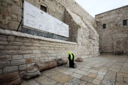 A pilgrim prays outside the Church of the Nativity in Bethlehem, West Bank, March 5, 2020. Palestinian authorities said the Church of the Nativity will close indefinitely due to coronavirus concerns.