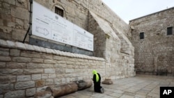 A pilgrim prays outside the Church of the Nativity in Bethlehem, West Bank, that Palestinian authorities have closed indefinitely due to coronavirus concerns.