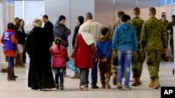 FILE - Syrian refugees wait at Marka Airport in Amman, Jordan, to complete their migration procedures to Canada, Dec. 8, 2015.