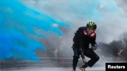 An anti-government protester is sprayed with blue-colored water by the police during a demonstration near Central Government Complex in Hong Kong, China, Sept. 15, 2019. 