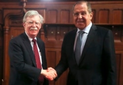 FILE - U.S. National Security Adviser John Bolton, left, and Russian Foreign Minister Sergey Lavrov shake hands prior to their talks in Moscow, Oct. 22, 2018.