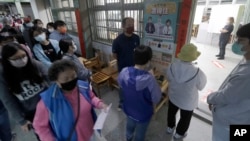 資料照片：2022年11月26日，台灣舉行“九合一”選舉。選民正在一個投票站等候投票。