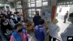 2022年11月26日，台湾举行“九合一”选举。选民正在一个投票站等候投票。