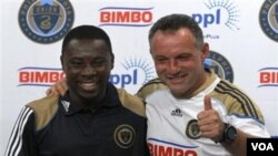 Freddy Adu (kiri) yang baru dikontrak klub MLS Philadelphia Union tersenyum di samping pelatihnya Peter Nowak dalam konferensi pers di Chester, Pennsylvania, Jumat (12/8).