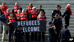 Faith leaders and members of human rights groups wearing a life vests symbolizing the life-saving program are arrested by Capitol police, during a protest calling on congress not to end the refugee resettlement program, at the steps of the U.S. Capitol i