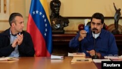 Nicolás Maduro muestra una copia de la Constitución junto a su vicepresidente Tareck El Aissami tras anunciar su disposición a someterse a un referendo.