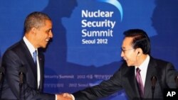 U.S. President Barack Obama, left, shakes hands with his South Korean counterpart Lee Myung-bak during a joint press conference following their meeting at the presidential Blue House in Seoul, South Korea, Sunday, March 25, 2012.