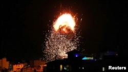 Smoke and flames rise above a building during Israeli airstrikes, amid a flare-up of Israeli-Palestinian fighting, in Gaza City, May 17, 2021. 