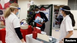 FILE - Walgreens Pharmacists prepare Pfizer-BioNTech coronavirus vaccines at Crown Heights Center for Nursing and Rehabilitation, a nursing home facility in Brooklyn, New York, Dec. 22, 2020.