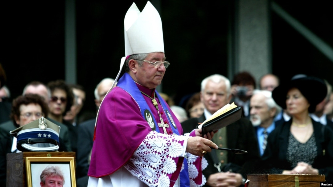 FILE - Poland's then-chief military chaplain Slawoj Leszek Glodz presides over a funeral in Warsaw, June 19, 2004. 