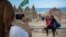 People pose for photos next to a sand sculpture of Pope Francis, Copacabana beach, Rio de Janeiro, July 16, 2013.