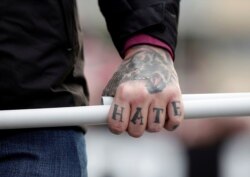 FILE - A tattoo is seen on a hand of a supporter of Italy's far-right Forza Nuova party during a demonstration in Rome, Italy, Nov. 4, 2017.