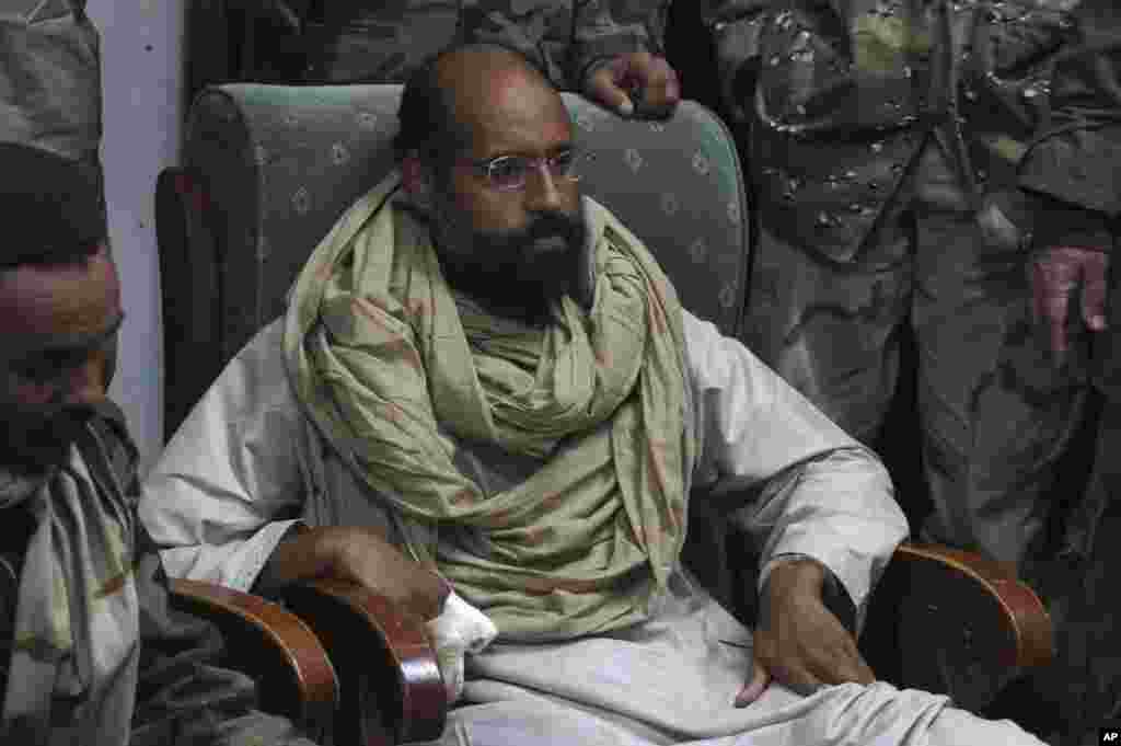 Saif al-Islam is seen after his capture, in the custody of revolutionary fighters in Obari, Libya November 19, 2011. Libya's prime minister-designate said Saif al-Islam would receive a fair trial in Libya. That could lead to conflict with the Hague-based