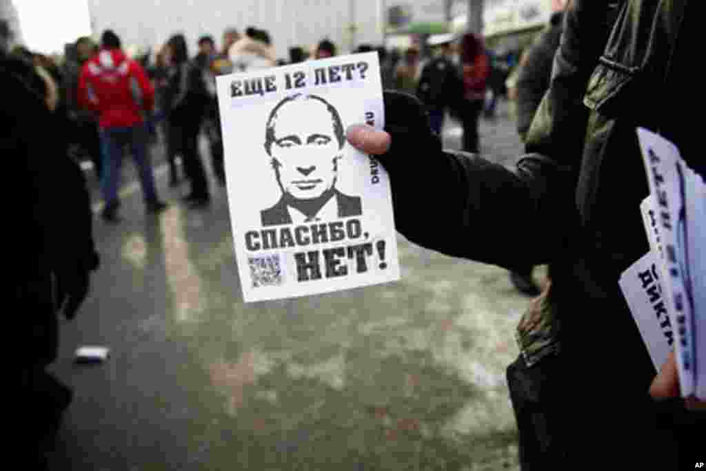 An activist hands out flyers that say, "12 more years? NO THANKS." February 4, 2012. (VOA - Y. Weeks)