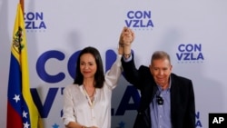 ARCHIVO - El candidato presidencial de la oposición Edmundo González, a la derecha, y la líder opositora María Corina Machado con las manos unidas en una conferencia de prensa un día después de las elecciones en Caracas, Venezuela, el lunes 29 de julio de 2024. 