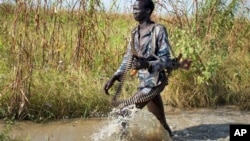 A rebel soldier patrols a flooded area near the town of Bentiu in Unity state. A report by the Geneva-based Small Arms Survey warns that both the rebels and government forces are planning new offensives in Unity state and elsewhere in South Sudan.