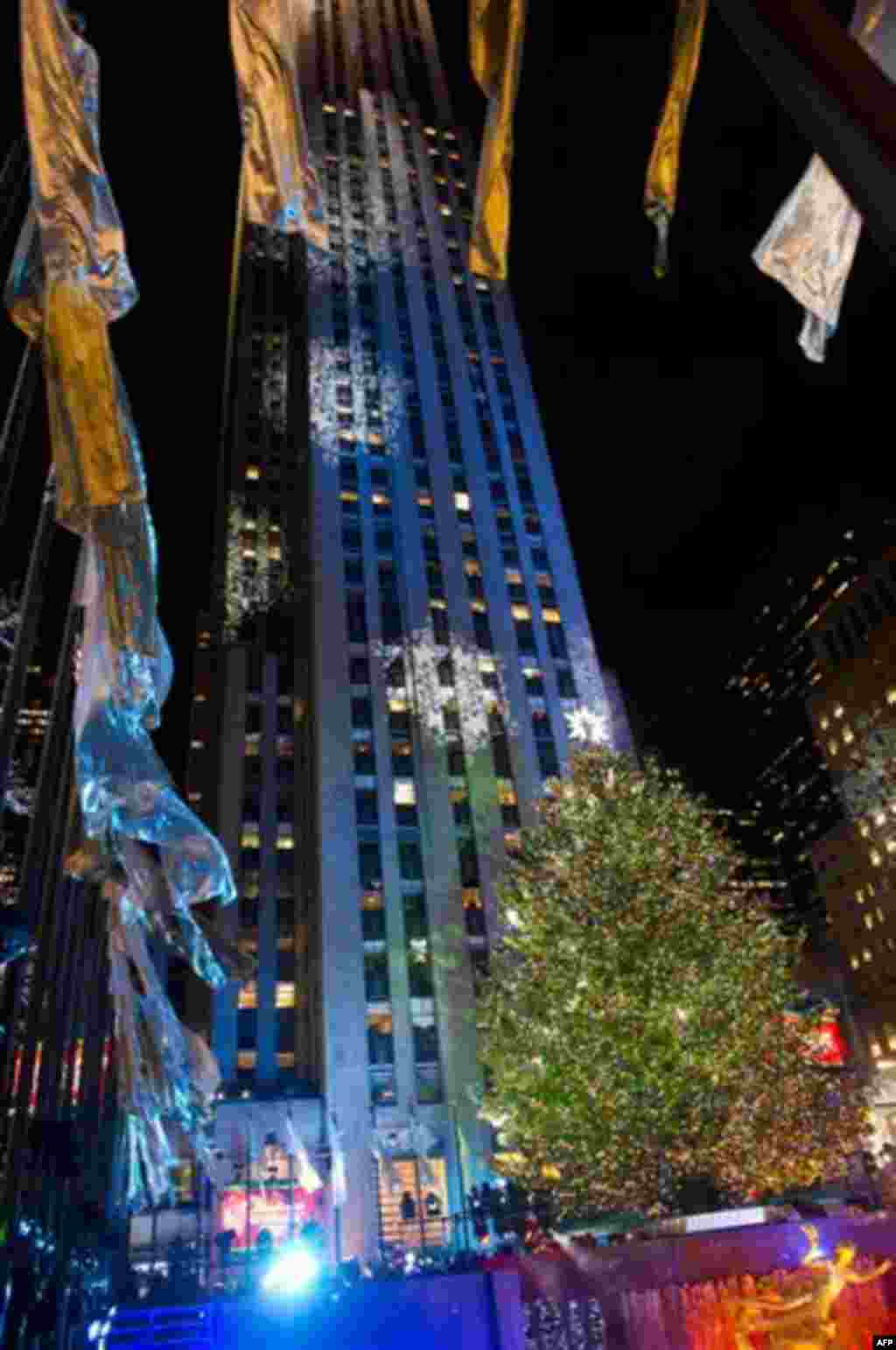 The 74-foot-tall Rockefeller Center Christmas tree is lit using 30,000 energy efficient LED lights during the 79th annual lighting ceremony, in New York, Wednesday, Nov. 30, 2011. (AP Photo/Charles Sykes)