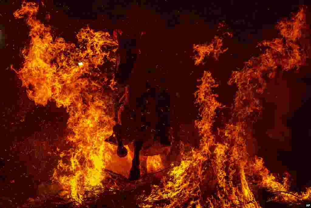 A man rides a horse through a bonfire as part of a ritual in honor of Saint Anthony the Abbot, the patron saint of domestic animals, in San Bartolome de Pinares, Spain, Jan. 16, 2022.