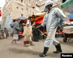 A health worker wearing a protective suit disinfects a market amid concerns of the spread of the coronavirus disease (COVID-19), in Sanaa, Yemen, April 28, 2020.