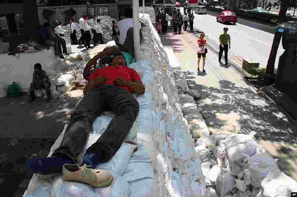 Workers having rest on a sandbag wall on Bangkok's Phahonyothin Road, October 27, 2011. ( VOA - D. Schearf)