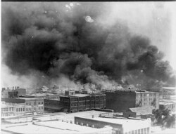 This June 1921 handout photo obtained May 19, 2021, courtesy of the Library of Congress, shows smoke billowing in the Greenwood neighborhood, during the burning of buildings after the Tulsa Massacre in Tulsa, Oklahoma.