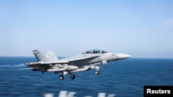 资料照片：美国海军公布的照片显示，一架美国海军的E/A-18G“咆哮者”电子作战飞机在阿拉伯海从美国海军“林肯号”航母上方飞过。(2019年5月22日)