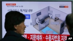 People watch a TV screen showing an image of solitary cell of Seoul Detention Center used by former South Korean President Park Geun-hye during a news program at the Seoul Railway Station in Seoul, South Korea, March 31, 2017.