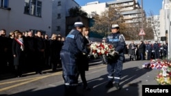 French President Macron and other officials take part in a ceremony commemorating the anniversary of an attack on Charlie Hebdo, outside the weekly's former offices in Paris, Jan. 7, 2025.