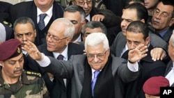 Palestinian President Mahmoud Abbas, center, gestures during a rally in the West Bank city of Ramallah, 25 Jan 2011