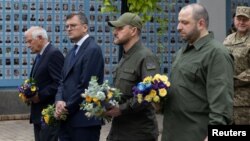 El jefe de política exterior de la Unión Europea, Josep Borrell, (izq) junto al ministro de Relaciones Exteriores ucraniano, Dmytro Kuleba, y otros altos funcionarios ucranianos en el Monumento a los Defensores Caídos de Ucrania en Kiev el 1 de octubre de 2023.