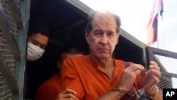 លោក James Ricketson អ្នក​ថត​ខ្សែភាព​យន្ត​ជន​ជាតិ​អូស្ត្រាលី​ត្រូវ​បាន​គេ​យក​ចេញ​ពី​រថយន្ត​មួយ នៅ​ពេល​លោក​មក​ដល់​សាលាដំបូង​រាជធានី​ភ្នំពេញ កាលពី​ថ្ងៃទី២៩ ខែសីហា ឆ្នាំ២០១៨។