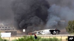 In this Saturday, July 26, 2014 frame grab from video obtained from a freelance journalist traveling with the Misarata brigade, shows an airplane on the tarmac of the airport belching black smoke into the air during fighting between the Islamist Misarata brigade and a powerful rival militia, in Tripoli, Libya. The battle for control of Tripoli's international airport began two weeks ago when Islamist-led militias - mostly from the western city of Misrata - launched a surprise assault on the airport, under control of rival militias from the western mountain town of Zintan. Heavy clashes in the country’s restive east between Libyan soldiers loyal to a renegade general and Islamist-led militias killed dozens of people including civilians, health officials said Sunday. On Saturday, the U.S. evacuated its diplomats in Tripoli to neighboring Tunisia and shut its embassy. (AP Photo/AP video)