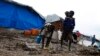 A boy carries a girl as they walk through the mud in an internally displaced persons (IDP) camp inside the U.N. base in Malakal, South Sudan, July 24, 2014. 