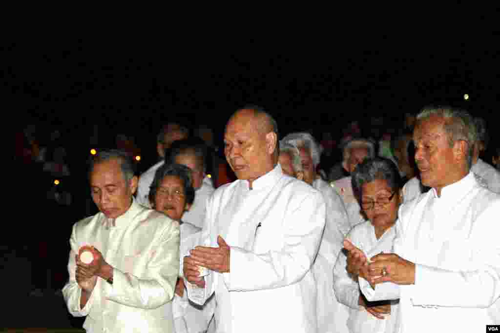 Tun Sovann, President of the Cambodian Buddhist Society, Inc, (right), leads a candle vigil around the main temple during a memorial service for Khmer Rouge victims at the Wat Buddhikaram Cambodian Buddhist temple in Silver Spring, Maryland, to mark the 40th anniversary of the takeover of the Khmer Rouge, on Friday, April 17, 2015. (Sophat Soeung/VOA Khmer)