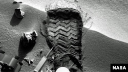 Gambar yang dirilis NASA ini merupakan gambar jejak roda yang terbentuk karena tiupan angin di Mars (Foto: dok). Kendaraan penjelajah Mars, Curiosity, akan mulai mengambil sampel tanah pertama dari planet merah itu, akhir pekan ini. 
