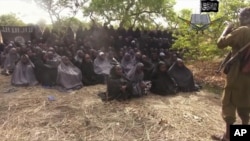 In this photo taken from video by Nigeria's Boko Haram terrorist network, May 12, 2014, shows the alleged missing girls abducted from the northeastern town of Chibok. 