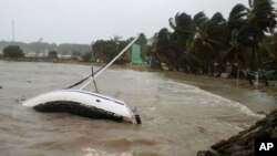 A boat lays on its side off the shore of Sainte-Anne on the French Caribbean island of Guadeloupe, early Sept. 19, 2017, after the passing of Hurricane Maria.