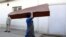 FILE - An Afghan man carries an empty casket in Kabul, Afghanistan, Sunday, July 15, 2018. Afghanistan has faced intense attacks by both the Taliban and the country's Islamic State affiliate recently.