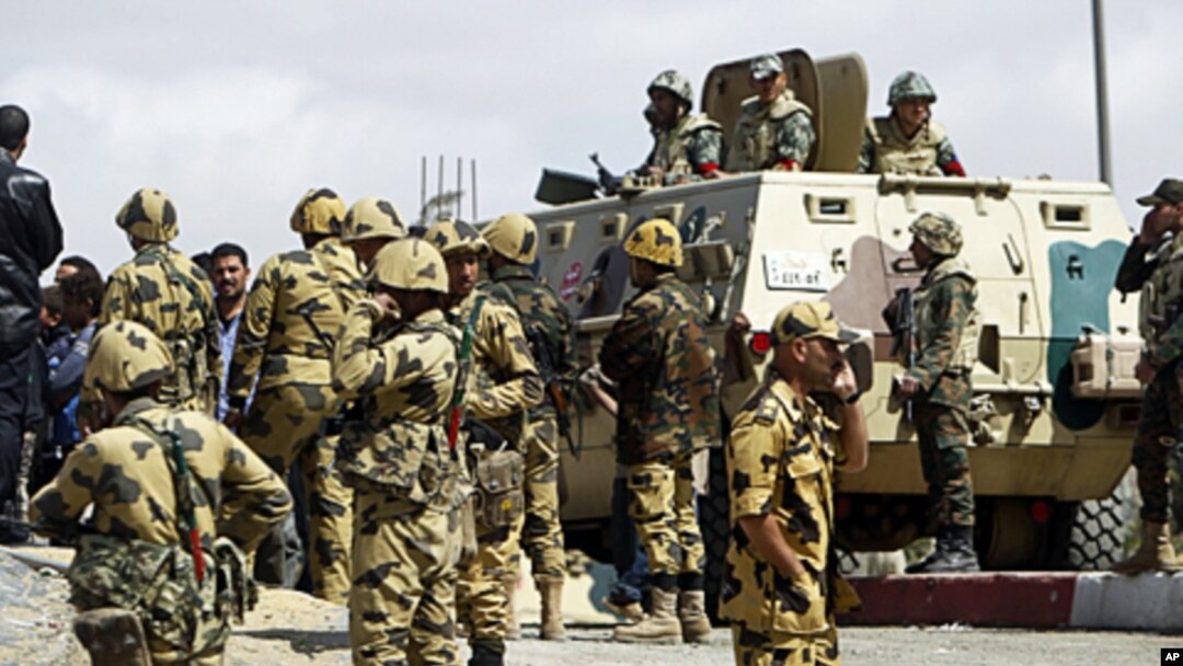 Egyptian army soldiers stand guard in Manshiyet Nasser shanty town in eastern Cairo, March 09, 2011