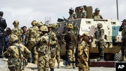 Egyptian army soldiers stand guard in Manshiyet Nasser shanty town in eastern Cairo, March 09, 2011